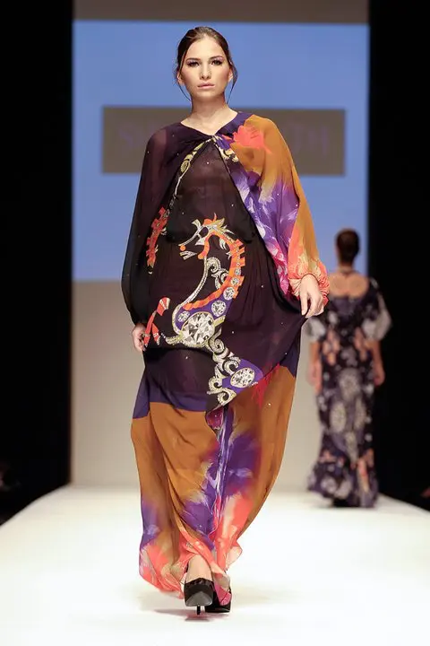 Arabian Nomads : Exclusive Arab Dress Collection at DFW, SS11 19 Long crinkled silk chiffon kaftan with ombre floral print in blue, orange, and purple, featuring a rearing horse and Islamic art motifs, with twisted sleeves ending in barrel cuffs.